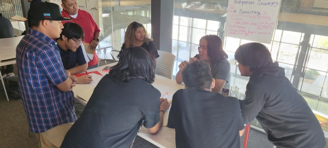Mr. Navenma facilitating high school youth, around the table discussion
