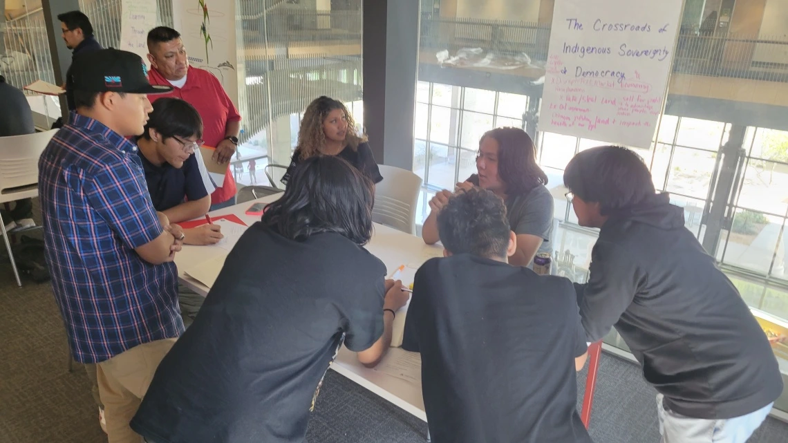Mr. Navenma facilitating high school youth, around the table discussion